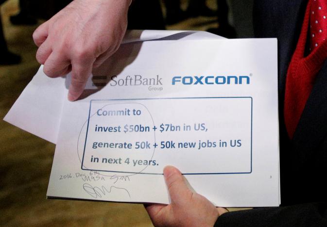 Softbank CEO Masayoshi Son shows a signed page to the press after meeting with U.S. President-elect Donald Trump at Trump Tower in Manhattan, New York City, U.S., December 6, 2016. REUTERS/Brendan McDermid