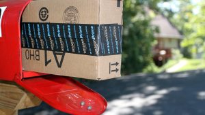 An Amazon shipping box in the mailbox in front of a home after being delivered.