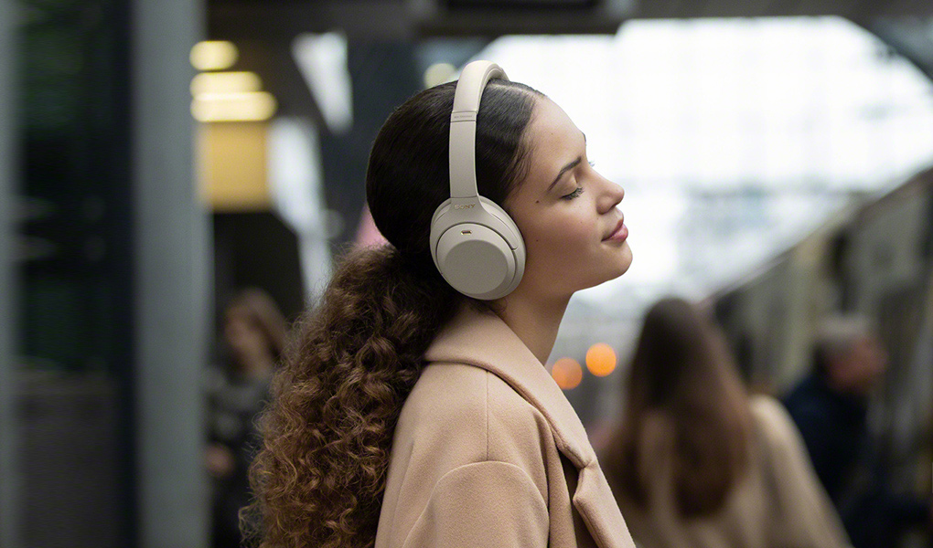 A woman listening to music on her Sony WH1000XM4 Wireless Noise Cancelling Headphones