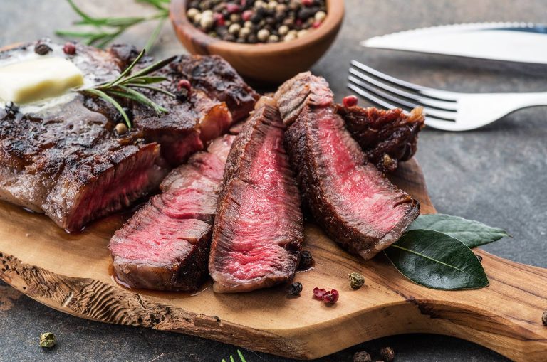 Steak cooked medium rare on a serving block