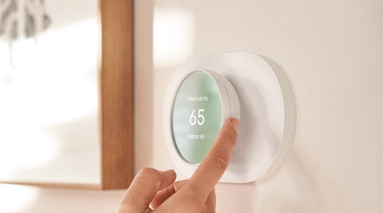 A person changing the temperature using a Nest Thermostat