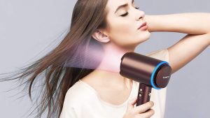 A woman drying her hair with the Tineco Moda One Smart Ionic Hair Dryer