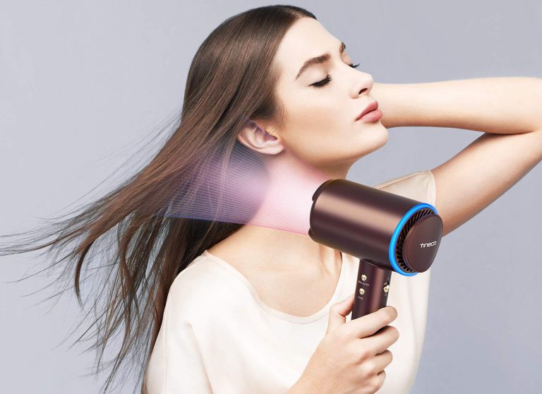 A woman drying her hair with the Tineco Moda One Smart Ionic Hair Dryer