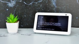 Amazon Echo Show 5 on a table next to a small potted plant