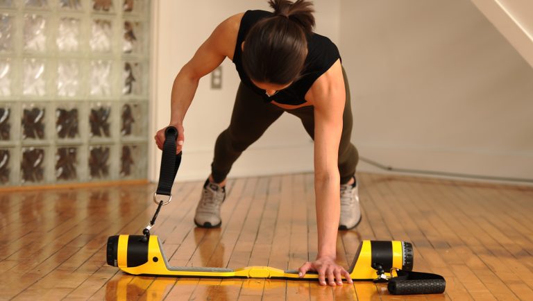 Best Home Gym Equipment For Small Spaces A woman using the MAXPRO cable gym to work out at home