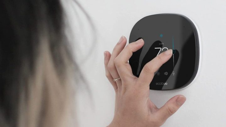An ecobee SmartThermostat adjusting the temperature in a woman's home
