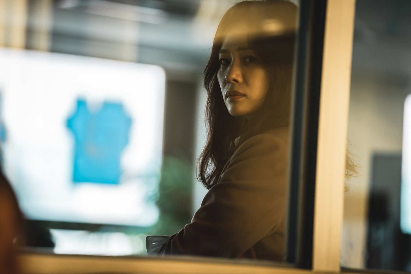 woman with dark hair looking out a window