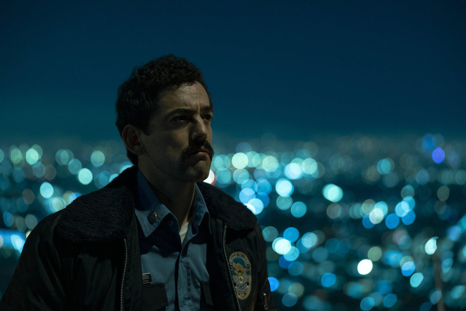 policeman at night in front of city lights