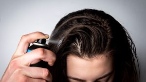 A person applying dry shampoo hair