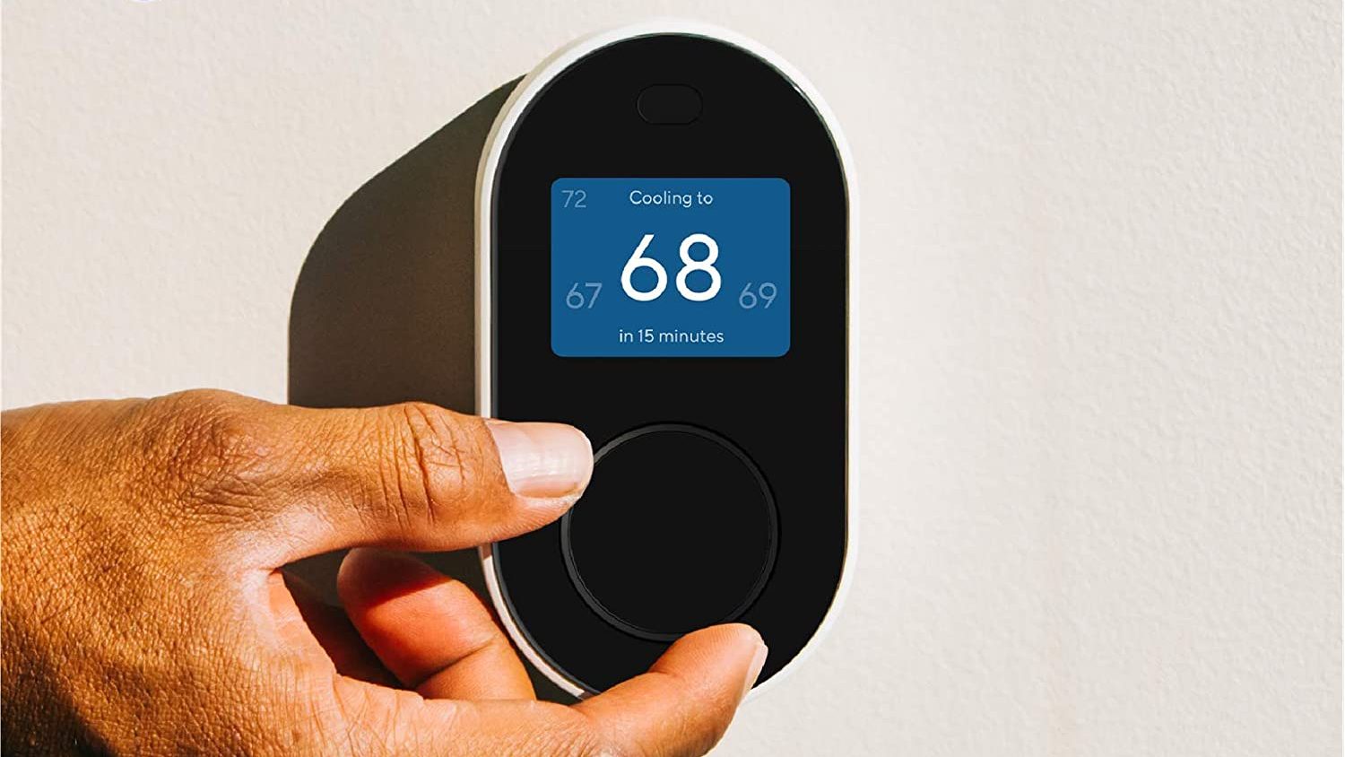 A person adjusting the thermostat.
