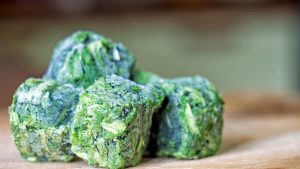 Frozen spinach cubes on a cutting board