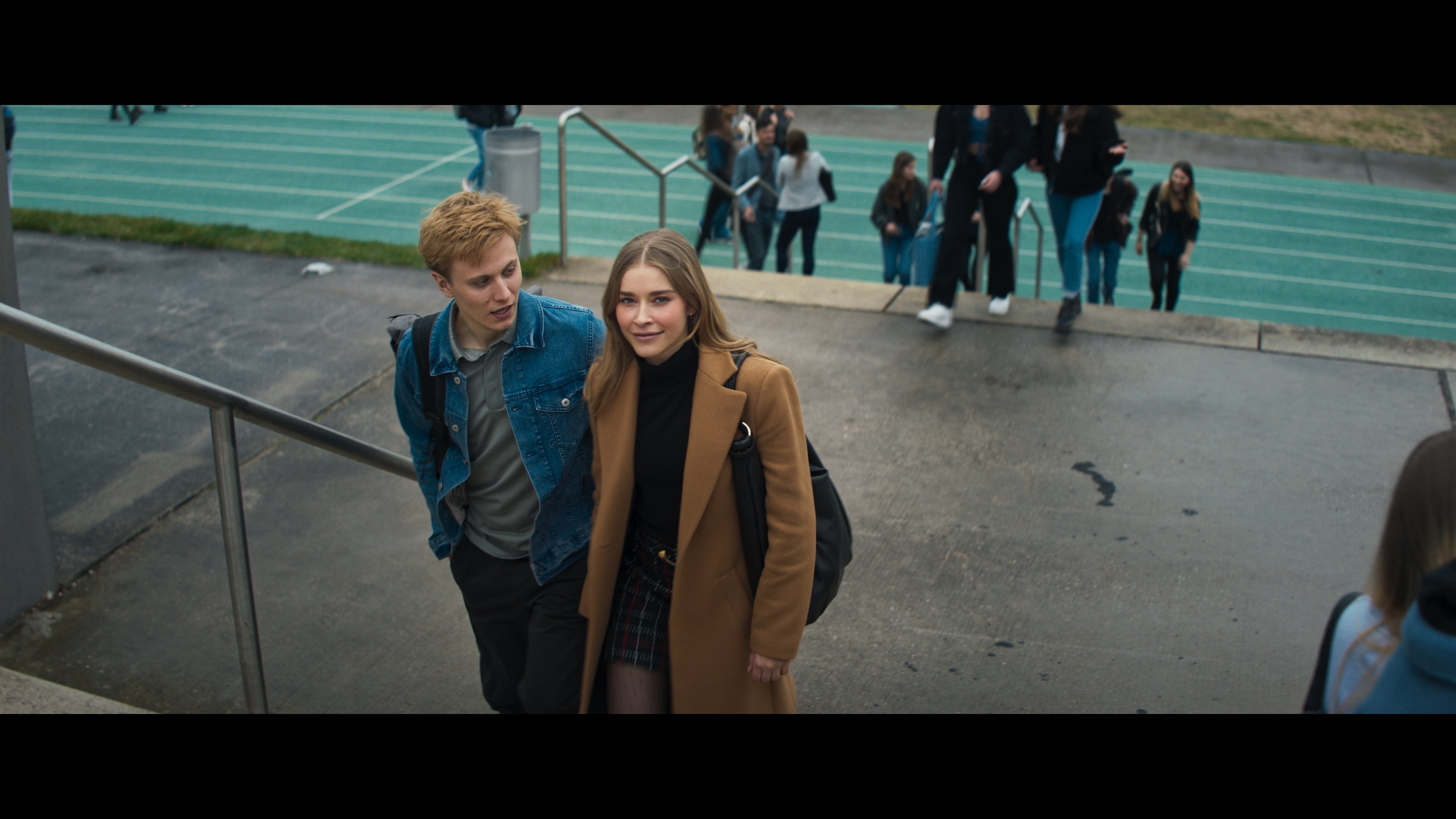 a young woman stands beside a young man