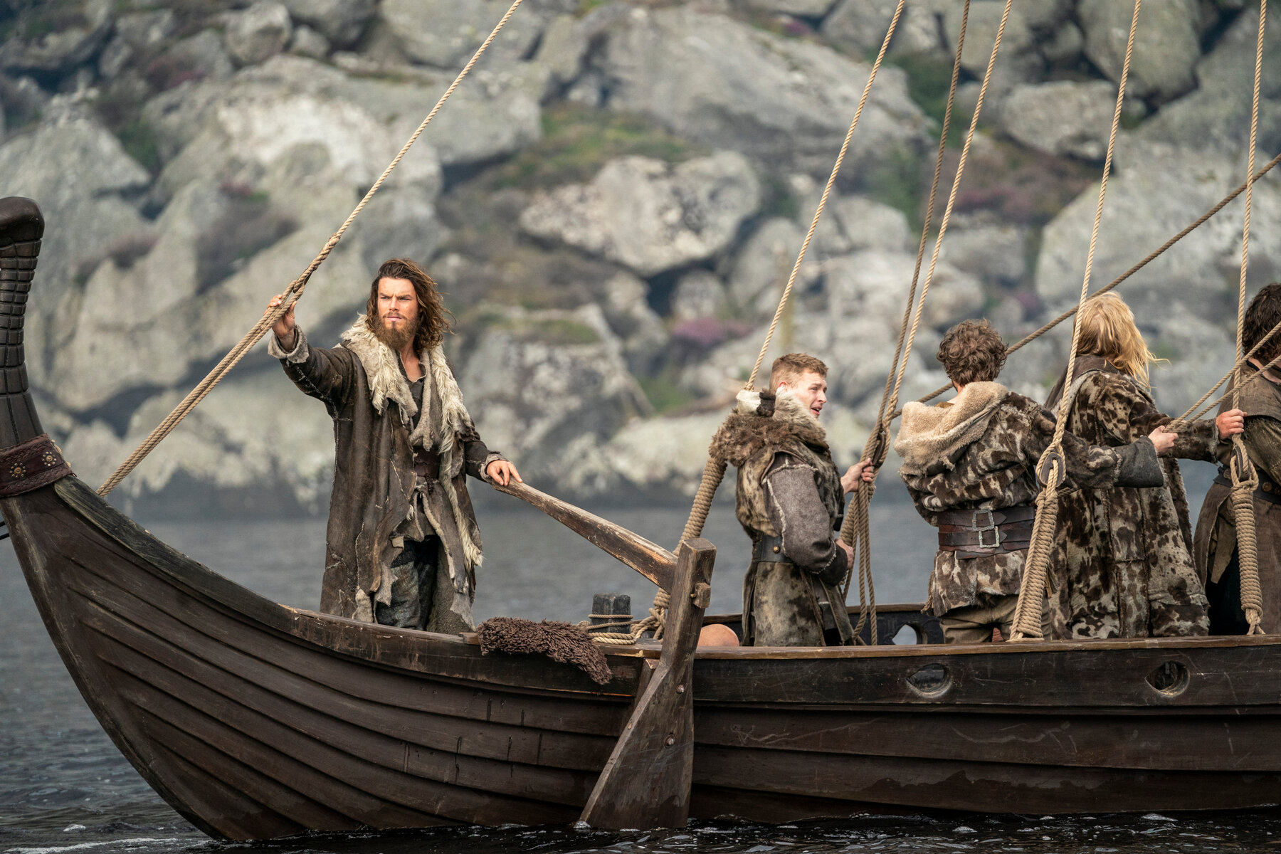 four people standing on a ship