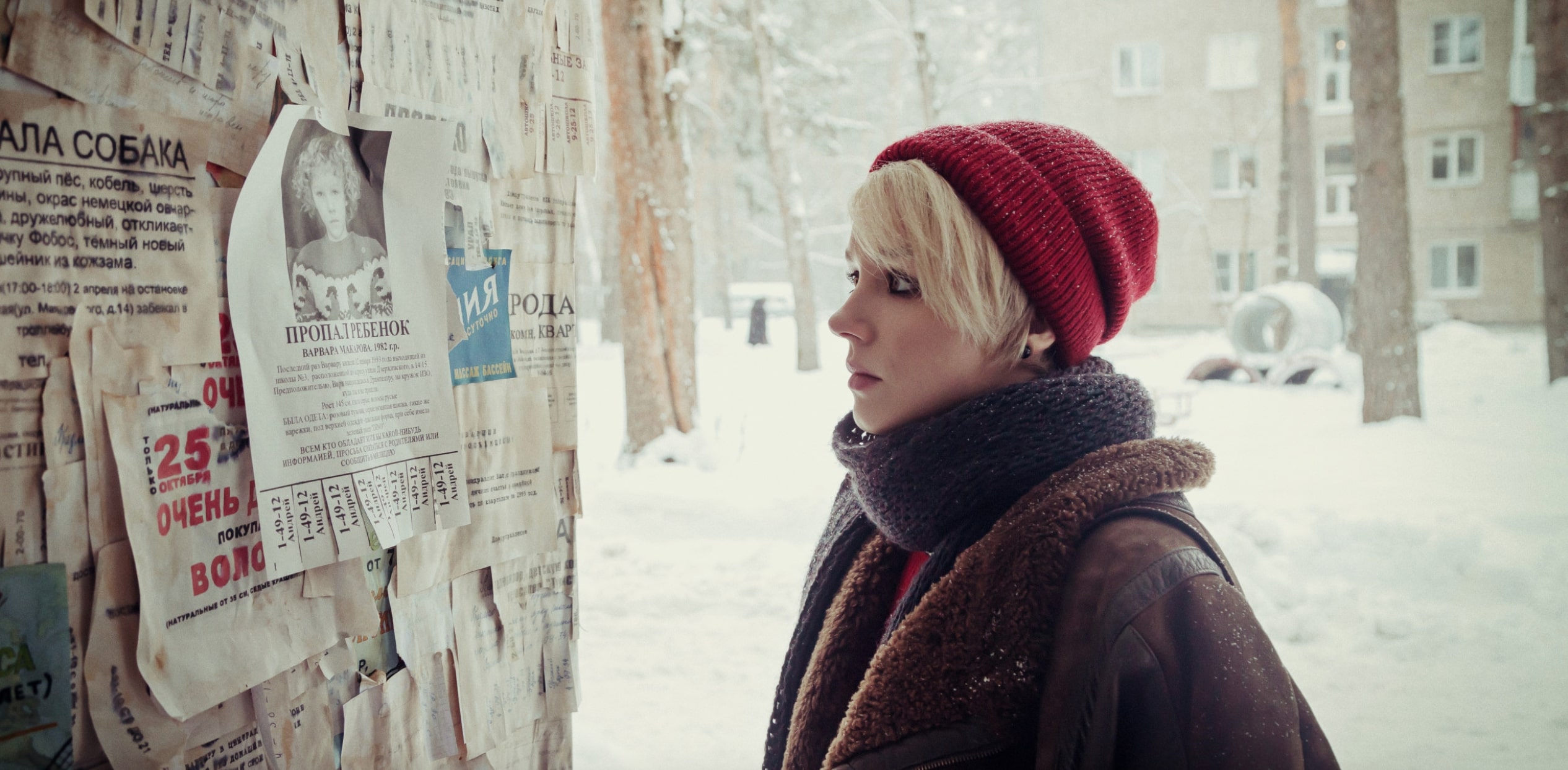 a young woman in a red knit cap with blonde hair