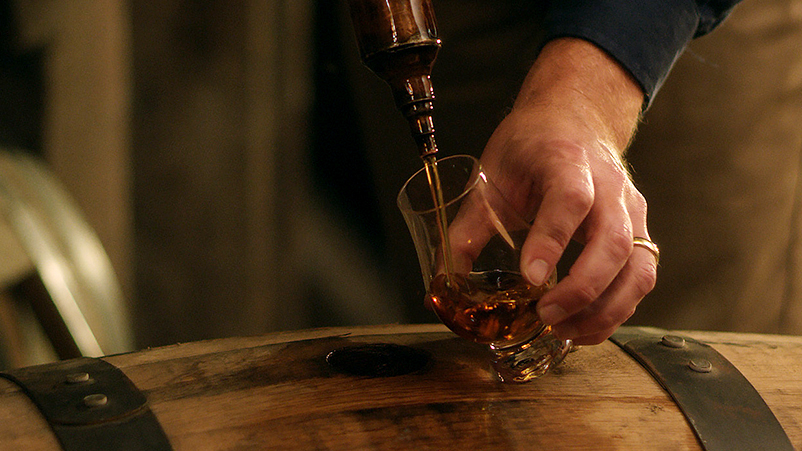 A person pouring whiskey