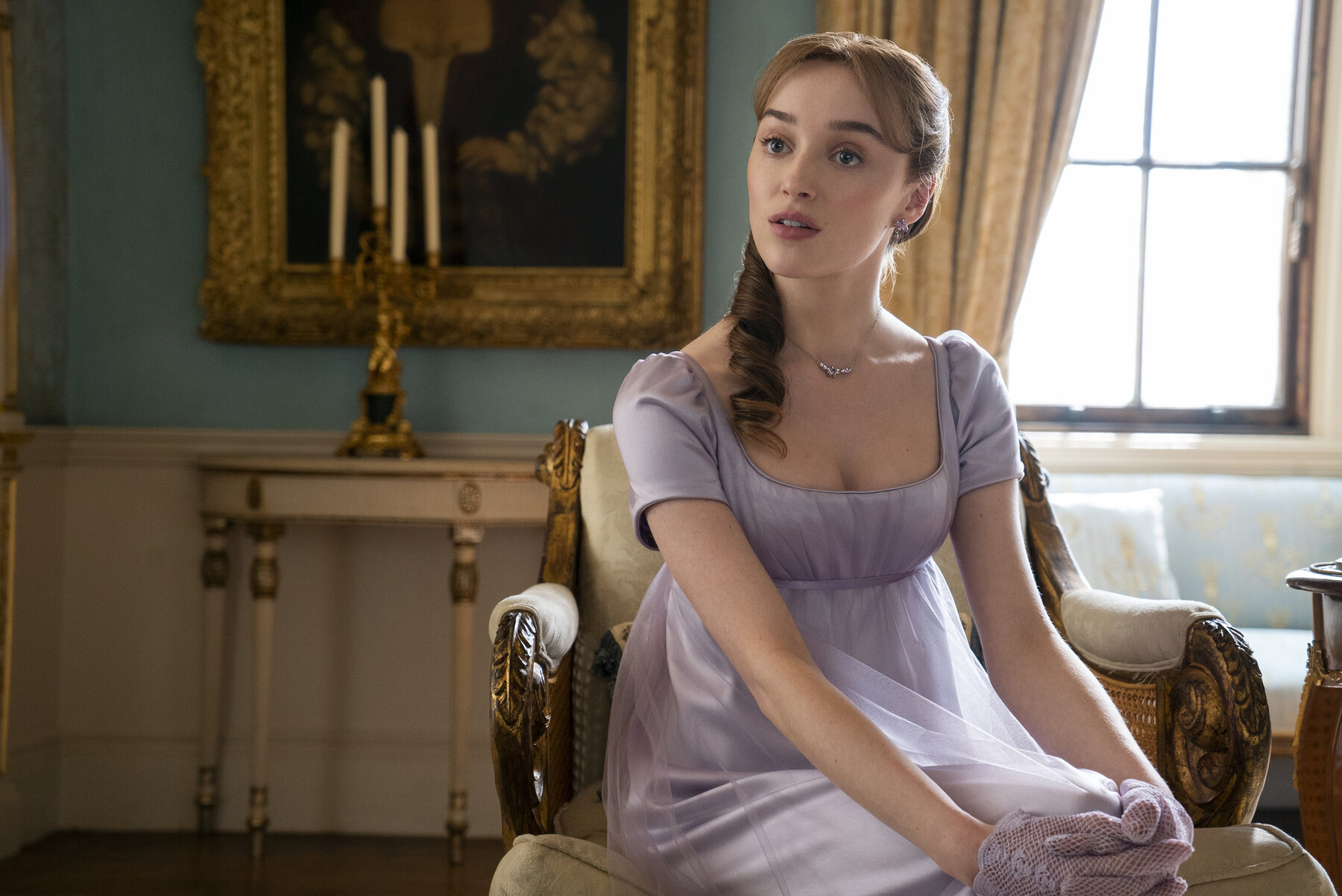 young woman with blonde hair seated wearing a dress