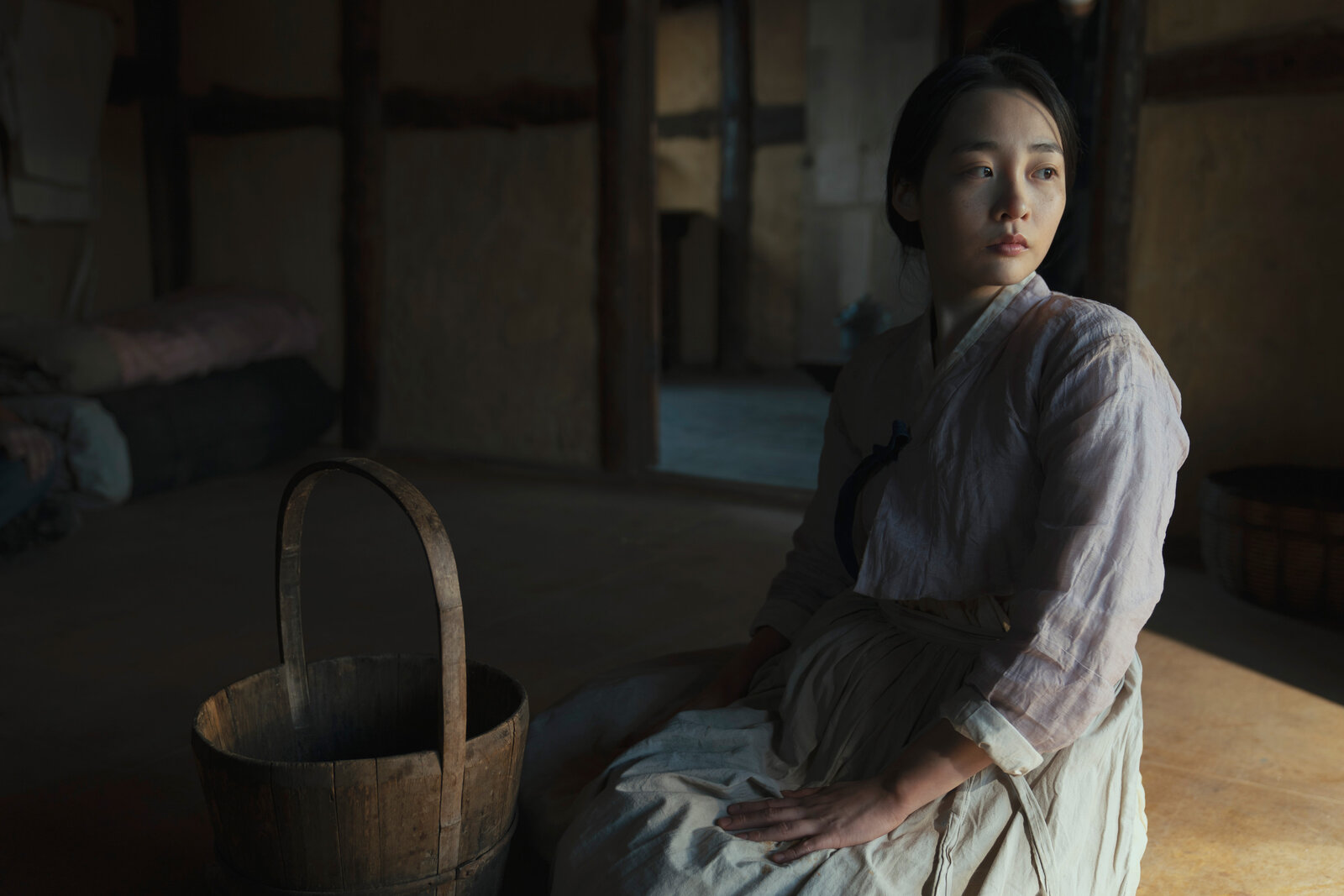 a young woman sits on the floor and looks over her shoulder