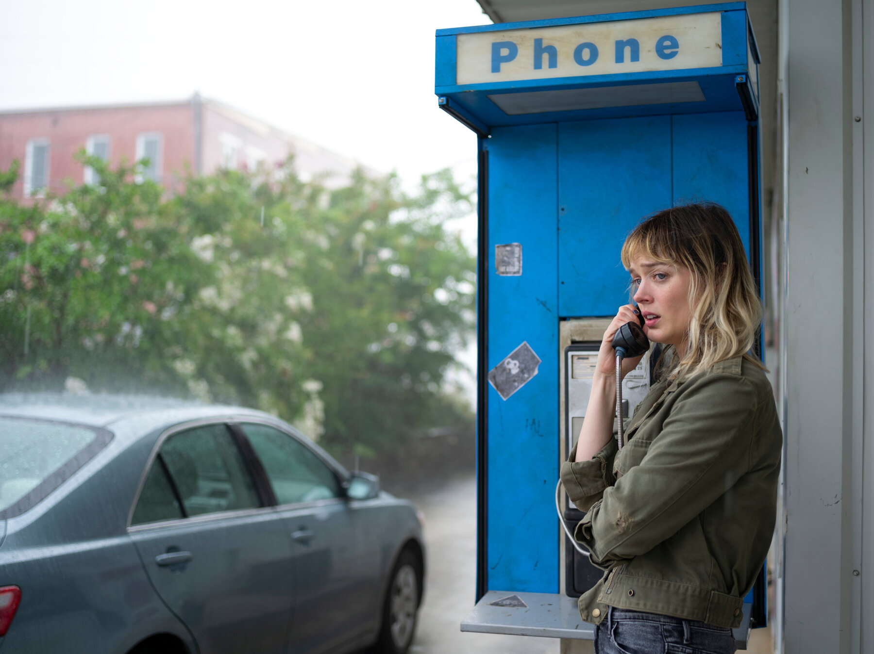 a young woman using a public telephone