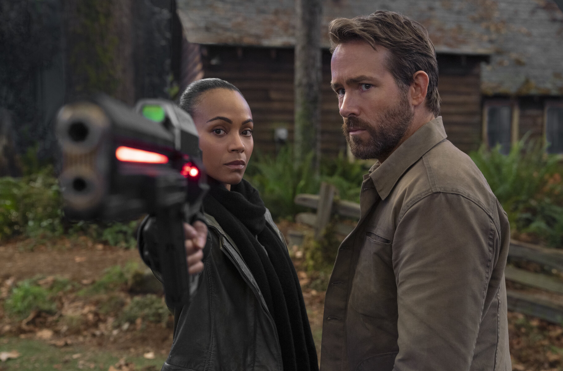 zoe saldana with a gun and ryan reynolds