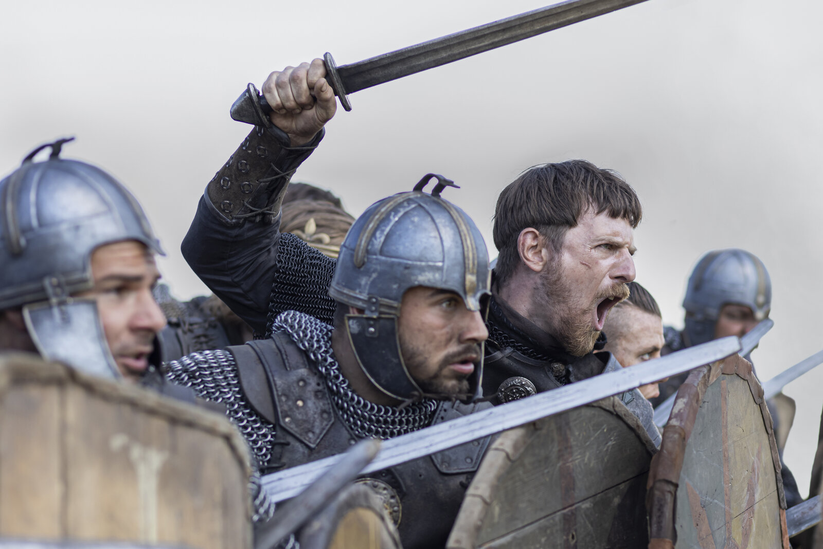 a row of soldiers in battle behind shields