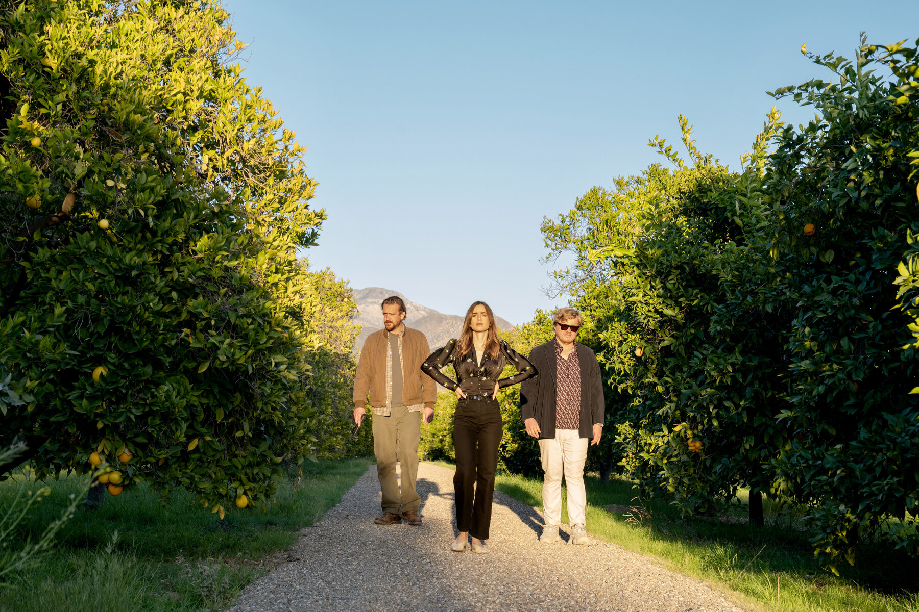 two men stand beside a woman