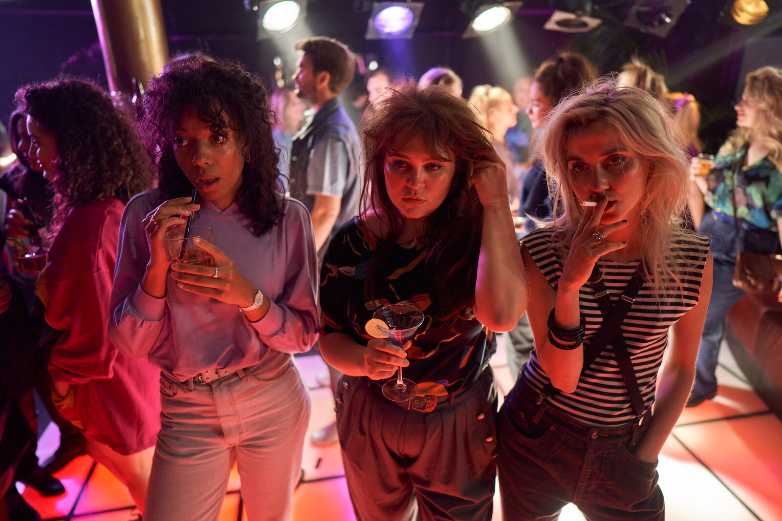 three woman stand together in a dance club