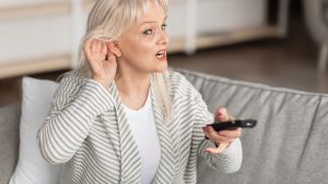 An older woman experiencing hearing loss.