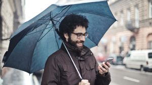 weather map man with umbrella holding phone
