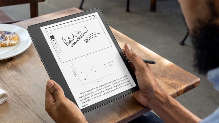 Kindle Scribe with a sticky note in a book.