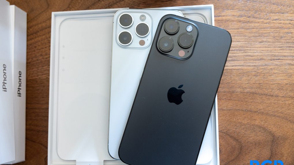 iPhone 14 Pro in Space Black and iPhone 14 Pro in Silver on a wood desk