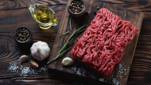 Raw fresh ground beef meat with seasonings.