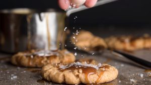 A person making salted caramel cookies.