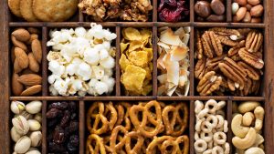 Variety of healthy snacks, overhead shot in a wooden box.