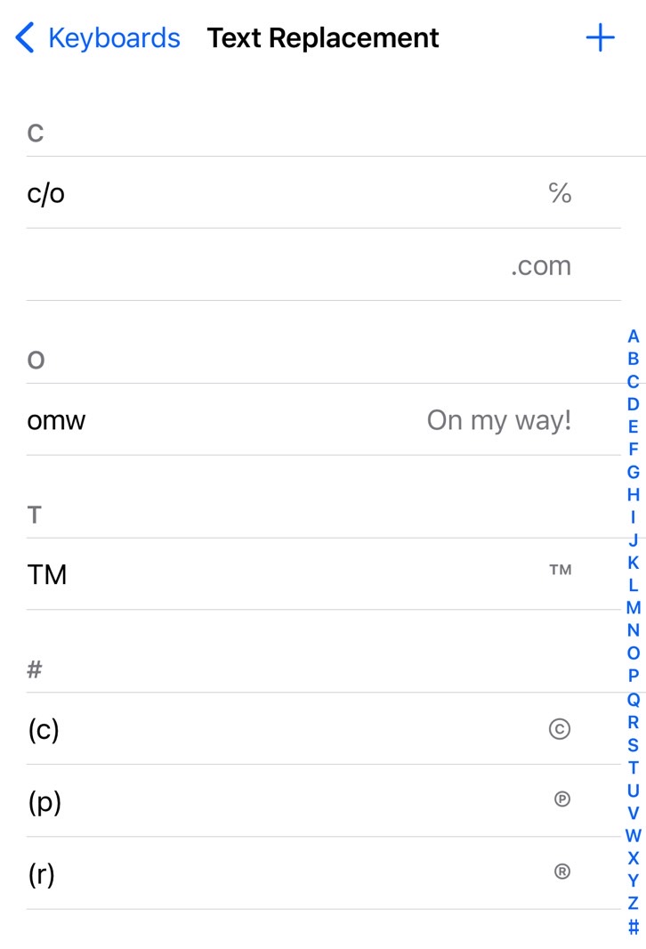 List of Text Replacement shortcuts in the iPhone's keyboard settings - the redacted ".com" shortcut is an email address.