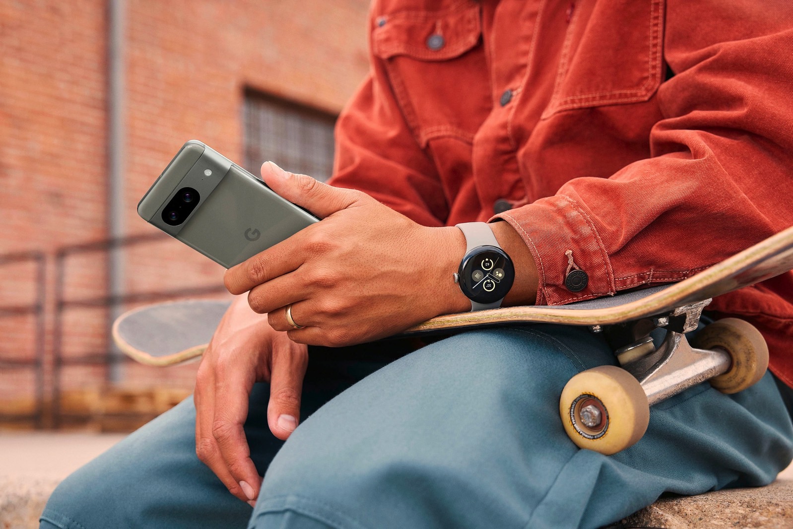 A person wearing a Pixel Watch 2 and using a Pixel 8 phone.