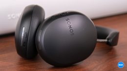 Sonos Ace headphones on front of a Sonos soundbar