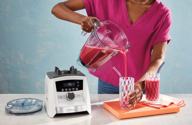 A person using a Vitamix Ascent blender.