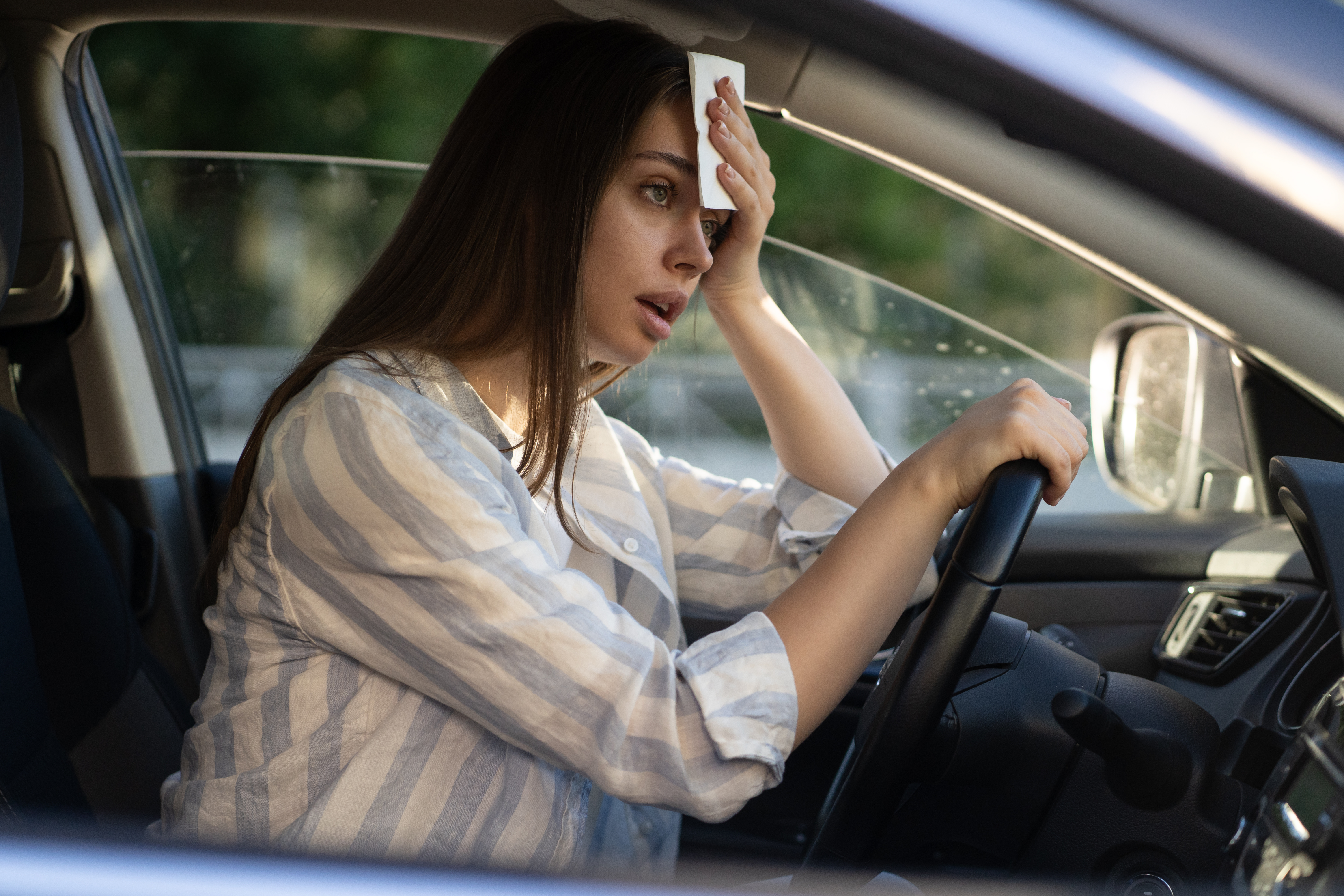 Girl driver being hot during heat wave in car