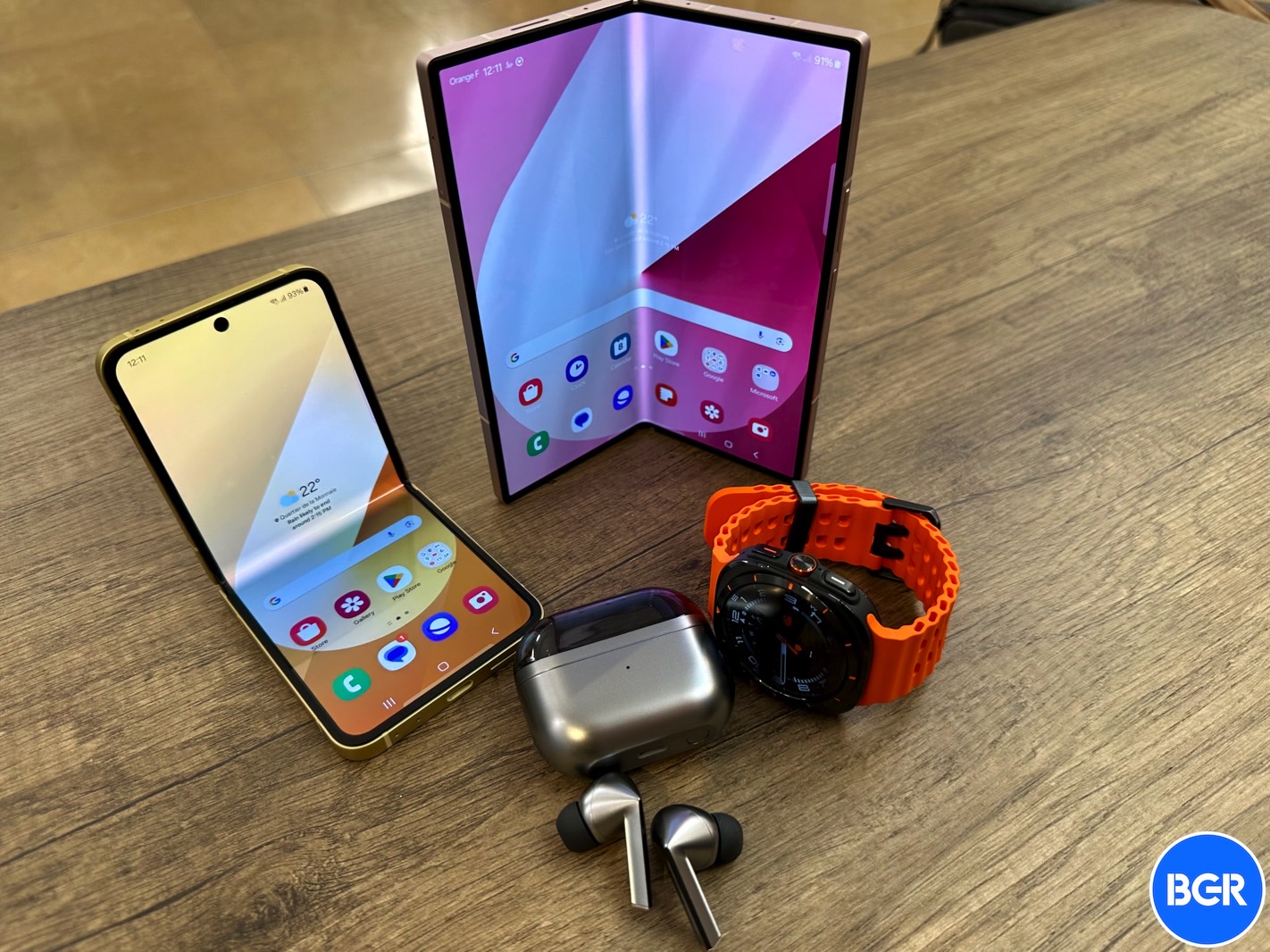 Galaxy Z Flip 6, Galaxy Z Fold 6, Galaxy Buds 3 Pro e Galaxy Watch Ultra sobre uma mesa.