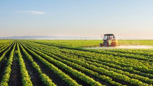 green ammonia farmland with tractor fertilizing field