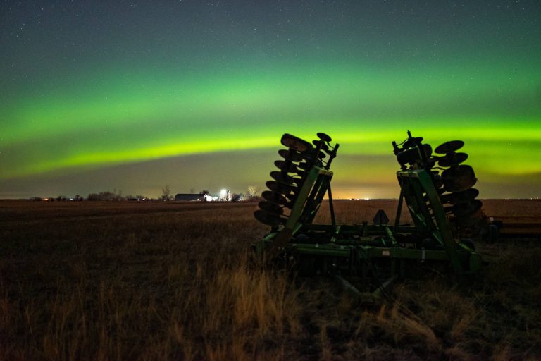 tractor plow with aurora in background